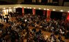 Gäste, Diplmandinnen und Diplomanden warten im Theatersaal auf den Start der Feier