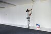 Ein Maler streicht die Wand in einem Klassenzimmer