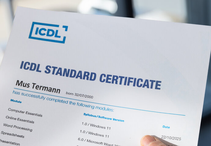 Hand mit ICDL Zertifikat in der Hand